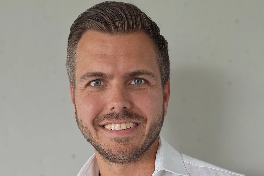 young man smiling against white wall